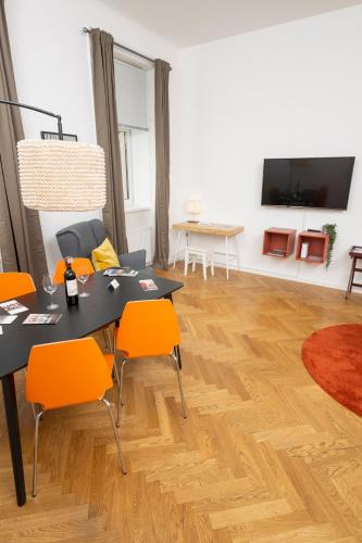 a dining room with a table and orange chairs at Luxury Suites Liechtenstein in Vienna