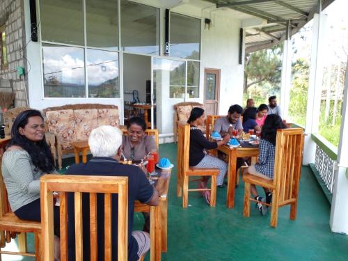 a group of people sitting at tables in a restaurant at Richard Homestay in Ella
