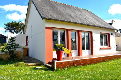 a small white house with a potted plant on the porch at Maison à 30m de la plage avec grand jardin in Plérin
