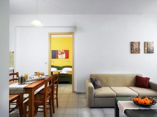 a living room with a table and a couch at Erivolos Studios & Apartments in Lygaria
