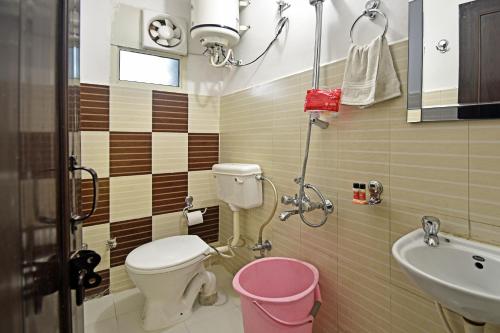 Baño pequeño con aseo y lavamanos en Hotel Gangotri, en Haridwar