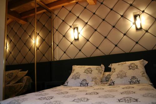 - une chambre avec un lit avec deux oreillers et deux lumières dans l'établissement Les Ecuries de la Tour, à Mondonville