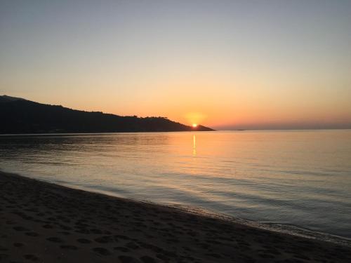 a sunset on the beach with the sun setting at Strada di a cuma in Vico
