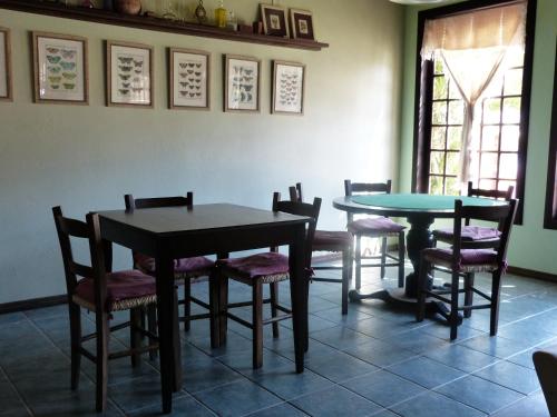 a dining room with two tables and chairs at Pousada Narinari in Bombinhas