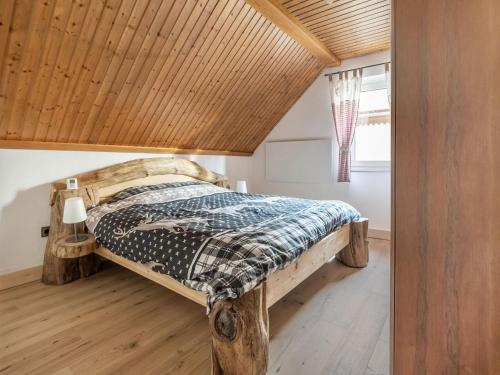 - une chambre avec un lit et un plafond en bois dans l'établissement Snug holiday home in Wei briach with terrace, à Weißbriach