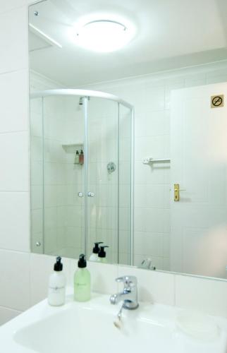 a bathroom with a sink and a mirror at Overmeer Guest House in Knysna
