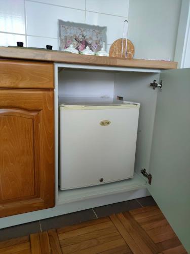 a white dishwasher in a kitchen under a counter at Apartman Zelenika in Banja Koviljača
