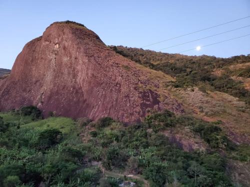 een berg in het midden van een veld met bomen bij Residencia Pedra do Elefante in Guarapari