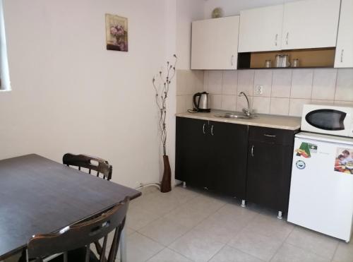 a kitchen with a table and a white refrigerator at Ivet Guest House in Obzor