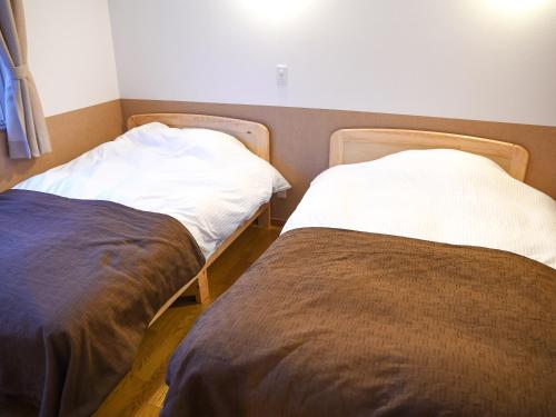 two beds sitting next to each other in a room at Mush Rooms in Higashikawa