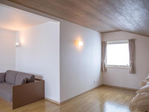 a living room with a couch and a window at Mush Rooms in Higashikawa
