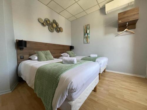 アルビにあるホテル ル ロッシュギュードのベッドルーム1室(ベッド2台、緑と白のシーツ付)