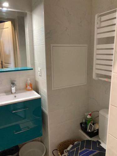 La salle de bains est pourvue d'une armoire bleue et d'un lavabo. dans l'établissement Profitez du Festival du Soleil de Cannes, à Cannes