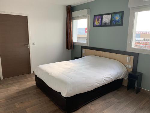 um quarto com uma cama e duas janelas em B&B HOTEL Romilly-sur-Seine em Romilly-sur-Seine