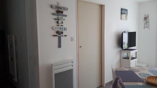 een kamer met een deur met een kruis aan de muur bij Étaules 10 min de la palmyre in Étaules