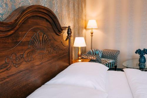 a bedroom with a large wooden headboard and a chair at Pension Relish in Rajecké Teplice