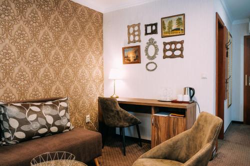 a hotel room with a desk and a couch at Pension Relish in Rajecké Teplice