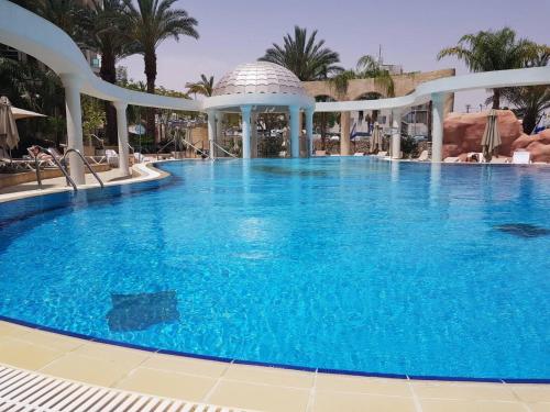 - une grande piscine d'eau bleue dans un complexe dans l'établissement TRENDY 2BR GOLF RESIDENCE EILAT, à Eilat