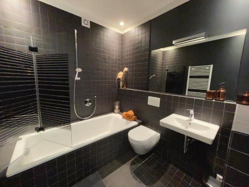 Un baño con bañera, inodoro y lavabo. en Weinloft "1" Design trifft Wein! Urlaub auf dem Weingut mit Ladestation E10, en Köwerich