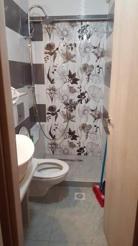 a bathroom with a toilet and a shower curtain at Perea white suites in Perea