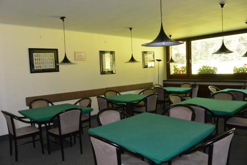 a dining room with green tables and chairs at Multiproprietà Rio Falzè in Madonna di Campiglio