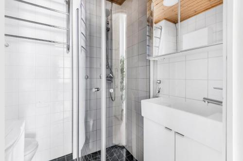 a white bathroom with a shower and a sink at WeHost Modern Scandinavian Studio in Trendy Kallio in Helsinki