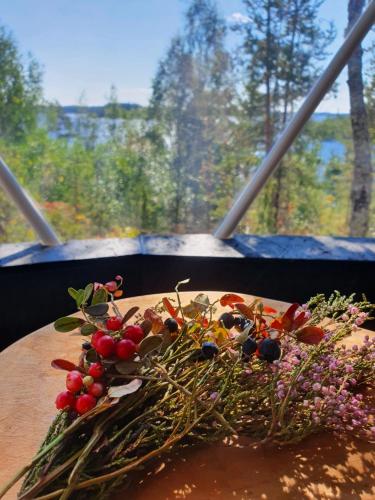 a bouquet of flowers on a table in front of a window at Hidden Island Laukanharju Glamping in Savonlinna