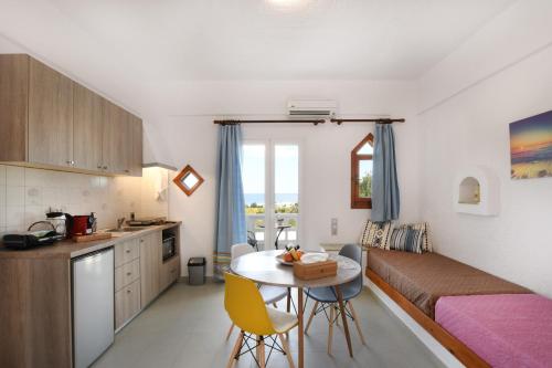 a small room with a bed and a table with chairs at Air Brand New Bedrooms in Hersonissos