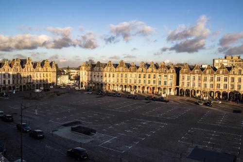 アラスにあるGrand Place Hôtel "Boutique et Appart'hôtel"の大きな建物前の大型駐車場