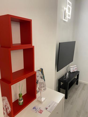 a living room with red shelves and a tv at Franz home and FREE parking Wi-Fi AC in Bolzano
