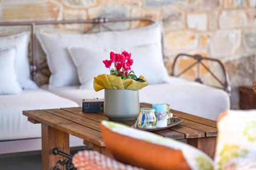 a coffee table with a vase of flowers on it at Pinelia Home in Mirtófiton