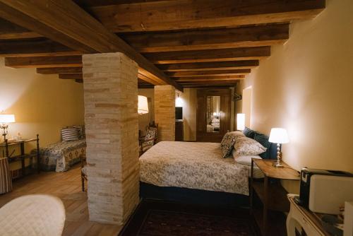 a bedroom with a bed and a stone pillar at Palazzo Romani Adami in Fermo