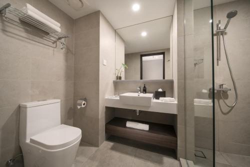 a bathroom with a toilet, sink and shower at Travelodge Bukit Bintang in Kuala Lumpur