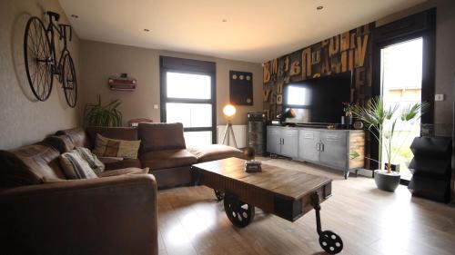 a living room with a couch and a coffee table at Chambre d'hôtes "Sur la route des Terrils" in Vendin-le-Vieil