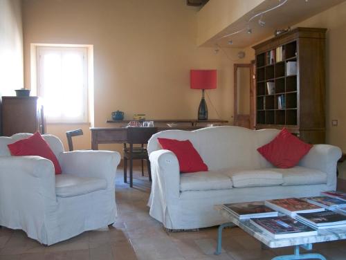 a living room with two white couches and a table at Palazzo Romani Adami in Fermo