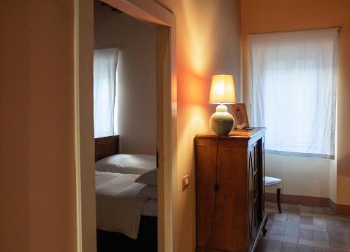 a bedroom with a bed and a lamp on a dresser at Palazzo Romani Adami in Fermo
