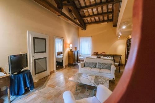 a living room with a couch and a tv at Palazzo Romani Adami in Fermo