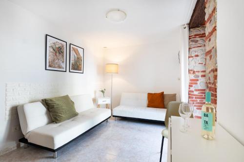 a living room with two white couches and a table at MarbellaTown in Marbella