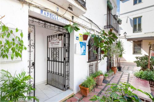 una entrada a un edificio blanco con una puerta negra en MarbellaTown, en Marbella