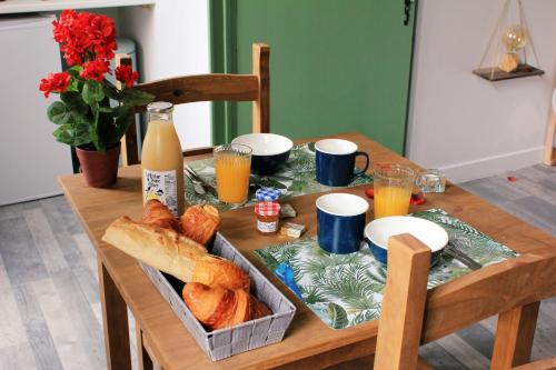 uma mesa com uma bandeja de pão e sumo de laranja em Le mas Roc'amour em Roquemaure