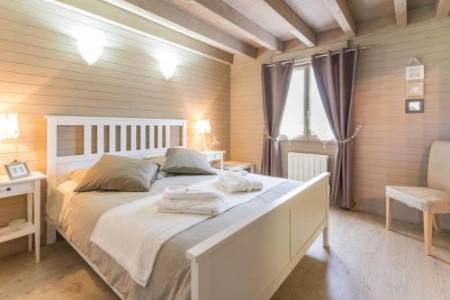 a bedroom with a large white bed and a chair at Sous le Cerisier in Venarey-les-Laumes