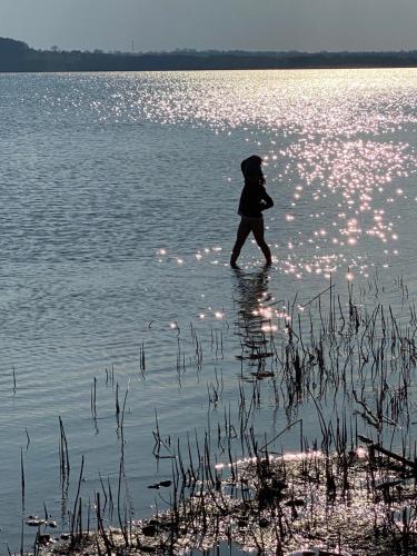 a person walking through a body of water at Marina Lubkowo Dom Czarna Perła in Lubkowo
