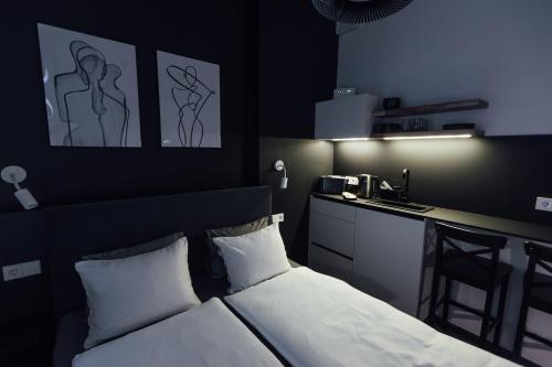 a bedroom with a bed and a kitchen with a bar at NEW! Elegant Park Studio with A/C near Old Town in Riga