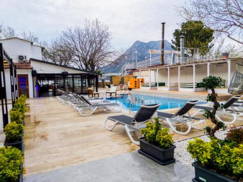 a resort with a pool and lounge chairs next to a building at Zulu Hotel in Kumluca