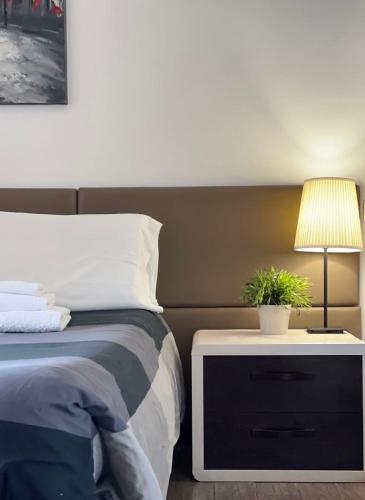 a bed with a night stand with a plant on it at Cameracaffè sul Lago in Arezzo