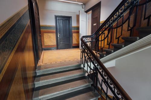 a hallway with stairs with a black door at Albert Studio in Art Nouveau building with AC Top location near old town in Rīga