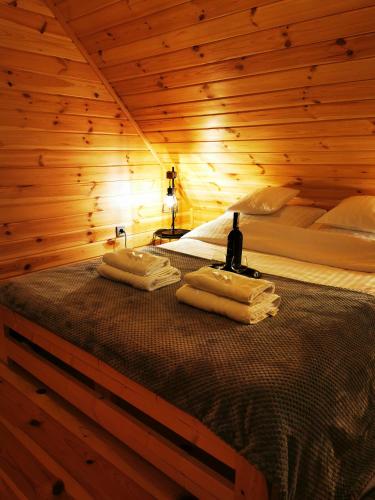 a bedroom with a bed in a wooden room at Domki przy plaży in Ryn