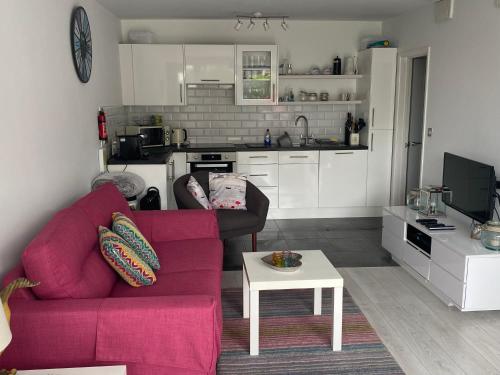 ein Wohnzimmer mit einem roten Sofa und einem Tisch in der Unterkunft Bay View, Millendreth Looe Cornwall in Looe