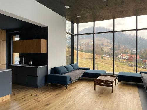 a living room with a blue couch and a table at Downhills Residence in Zázrivá