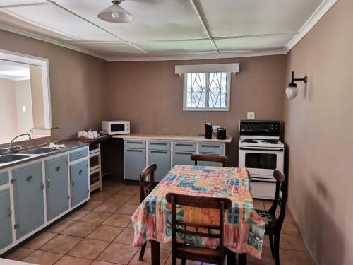 a kitchen with a table with chairs and a sink at Nandi's Place in Harrismith